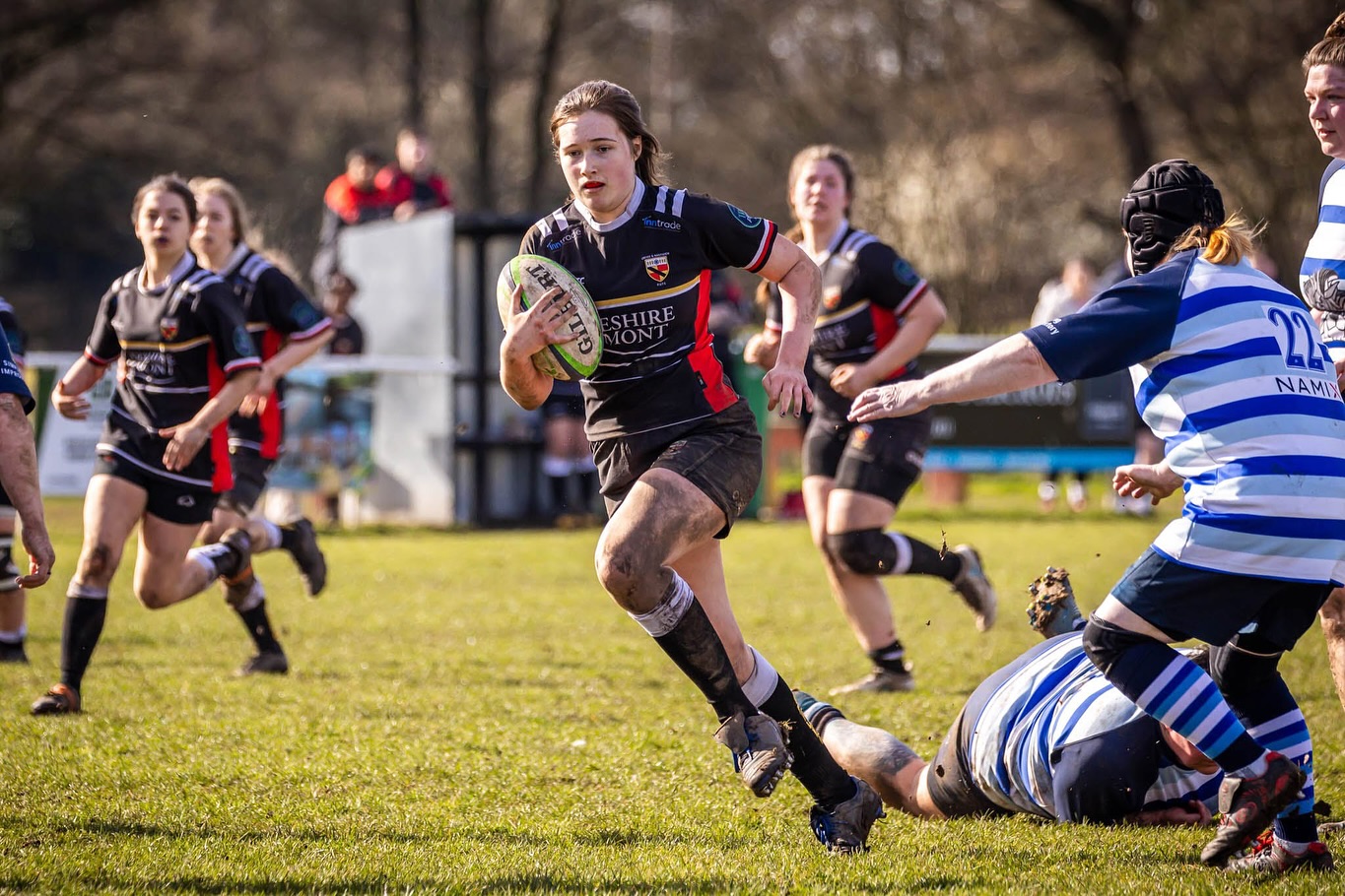 Young female running during rugby game with the rugby ball